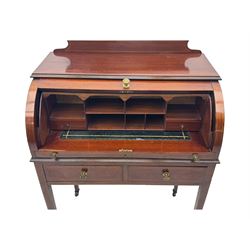 Edwardian inlaid mahogany roll-top desk, cylindrical lid enclosing fitted interior with pigeonholes, drawers and retractable writing surface, over two drawers with brass pull handles, on tapered supports with brass and ceramic castors