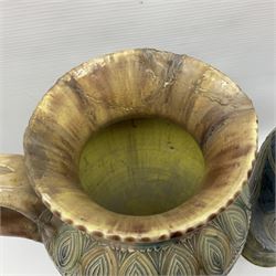 Early 20th century Royal Doulton stoneware vase, decorated with a stylized floral design below a wavy rim, monogrammed B.N, possibly for Bessie Newbery, H28cm, together with an early 20th century glazed jug, heavily carved throughout (2)