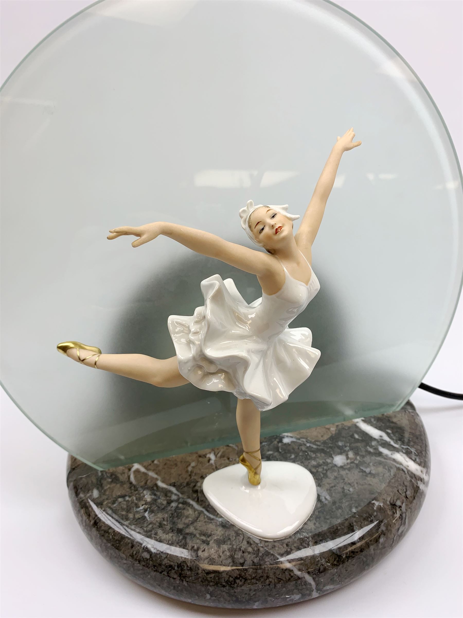 A table lamp with circular frosted glass shade, behind a later mounted continental figure modelled as a ballet dancer, H37cm. 