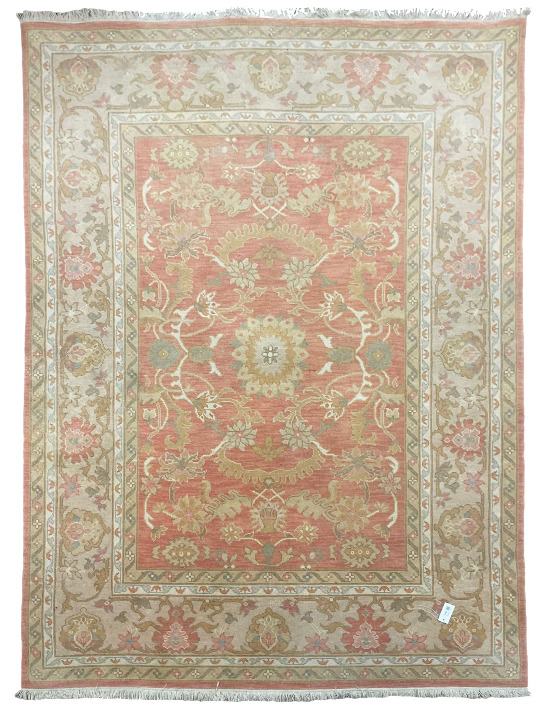 Persian Zeigler design rug, peach ground decorated with trailing branches and stylised plant motifs, the guarded border decorated with further plant moitfs