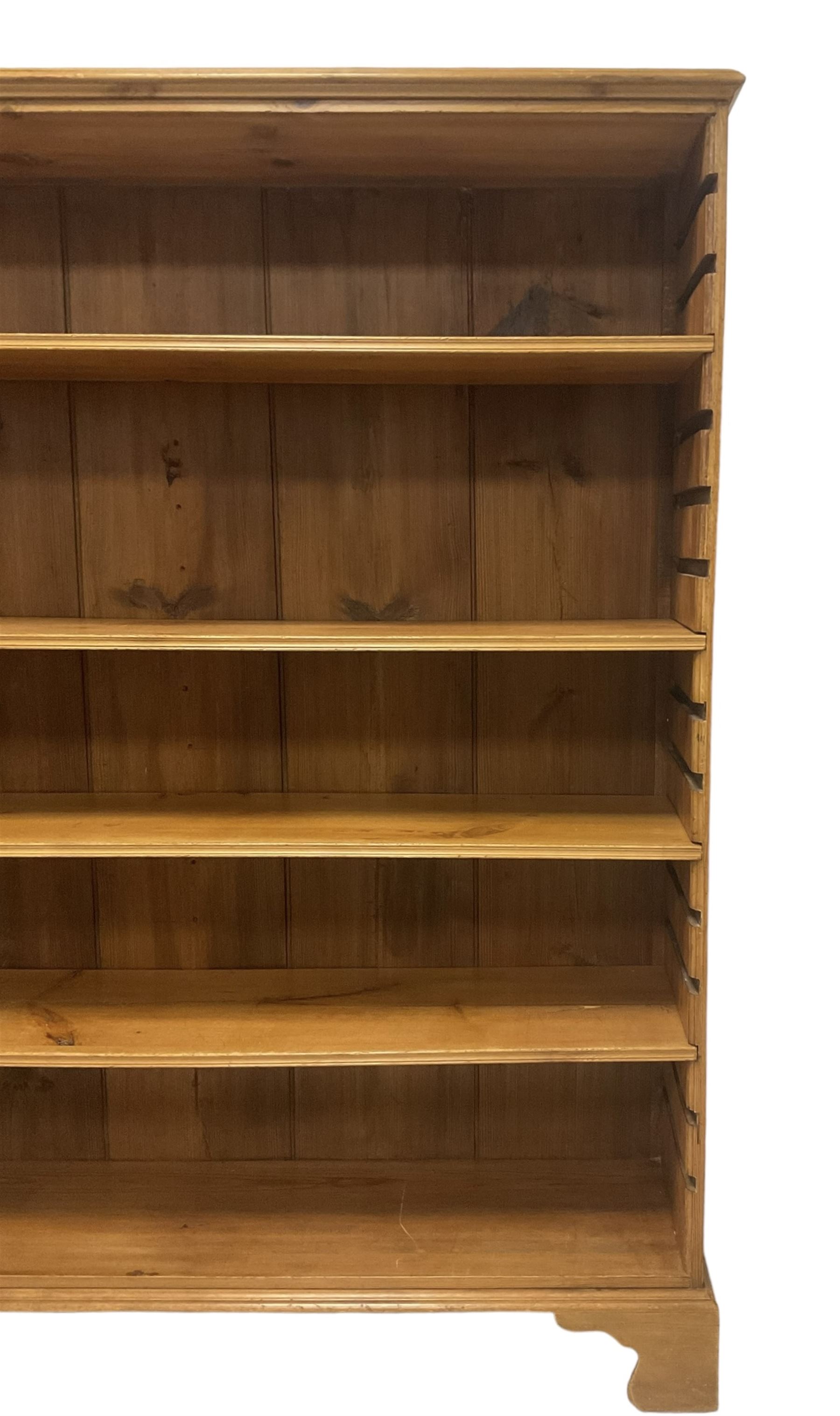 Georgian and later pine open bookcase, fitted with three adjustable shelves, on bracket feet