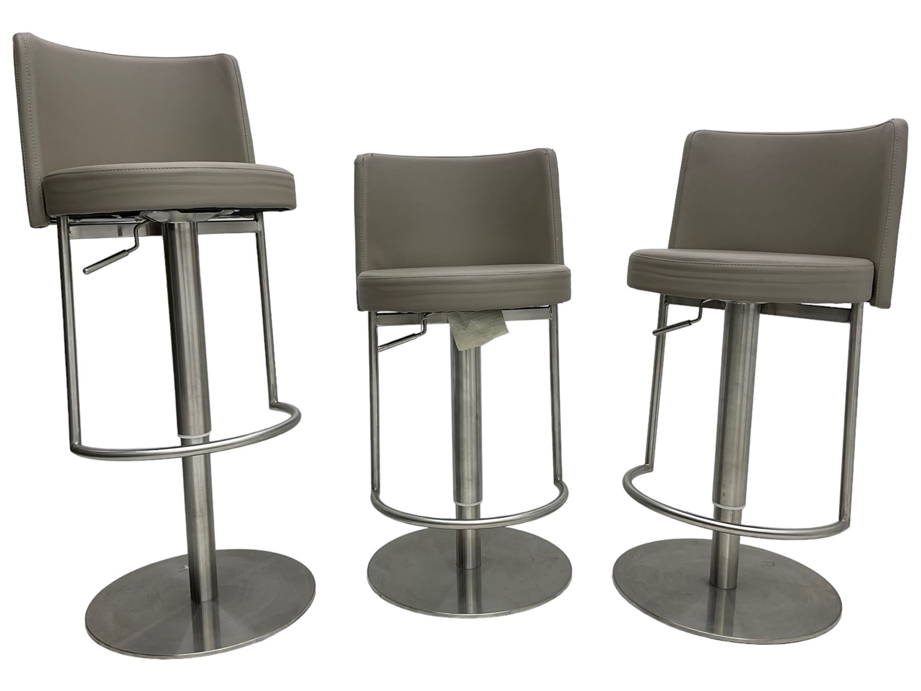 Three contemporary polished metal adjustable Monza bar stools, with taupe faux leather upholstered seats, supported by a brushed stainless steel pedestal base with integrated footrests