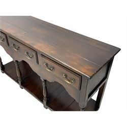 Georgian design oak dresser base, rectangular three plank top over three drawers and shaped apron, moulded drawer fronts with brass swan neck handles and circular plates, turned supports on panelled pot board base