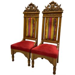 Set of six 20th century Carolean design oak high back chairs, the pediment carved with dragons and central Green Man mask with trailing foliage, the backs upholstered in striped fabric, on turned front supports