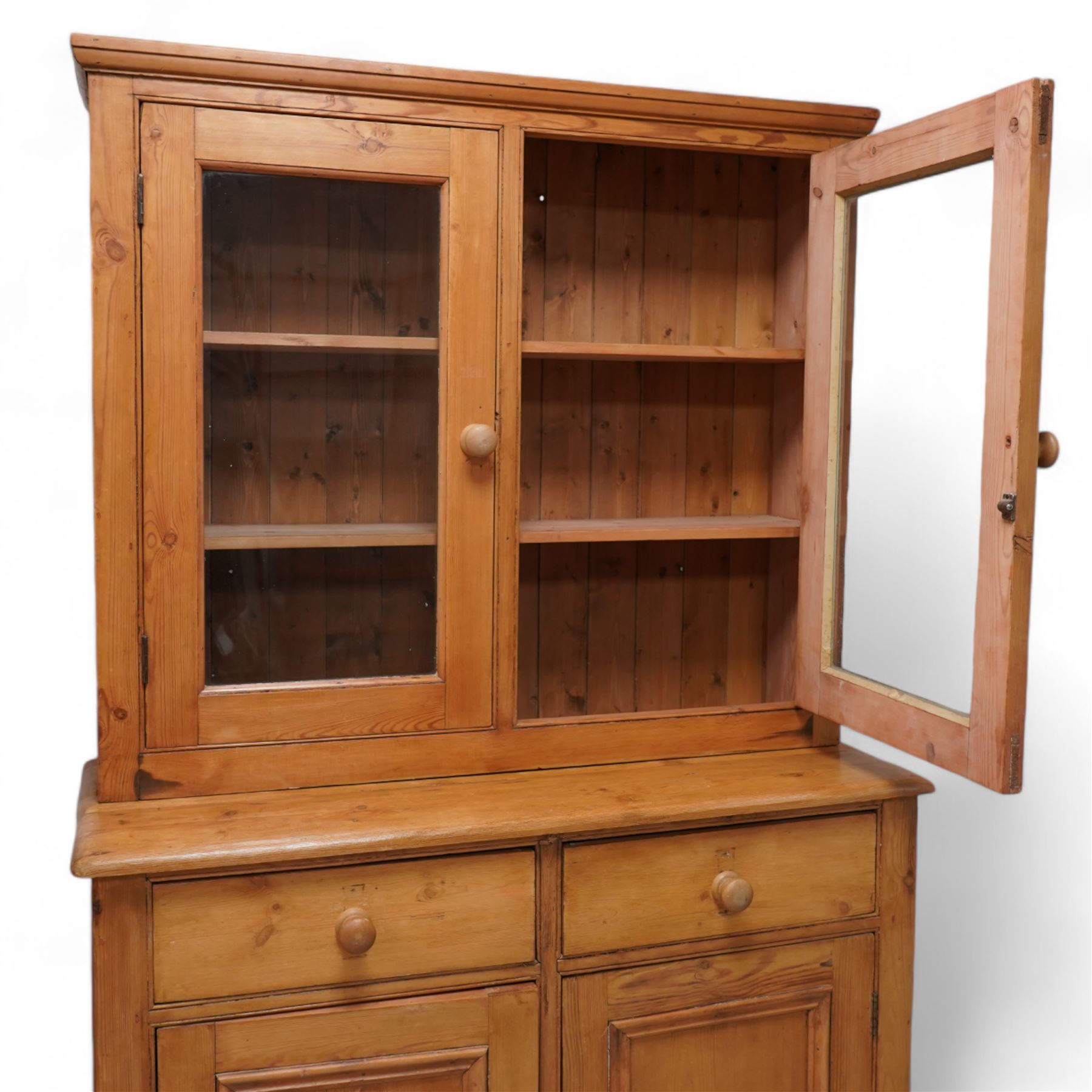 Late 20th century waxed pine dresser, raised display cabinet enclosed by two glazed doors, the base fitted with two drawers over panelled cupboard, on plinth base