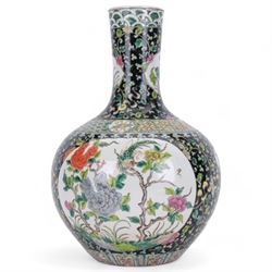 19th century Chinese famille noire bottle vase, decorated with two large reserves painted with ho ho birds amidst blossoming peonies, and six smaller reserves of flowers, against a black ground profusely decorated with leafy tendrils, with character mark beneath, H36cm