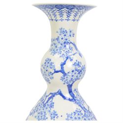 Japanese Meiji period porcelain double gourde vase, painted in blue with birds perched on a blossoming tree, within scroll and foliate borders, impressed seal mark beneath, H43.5cm 