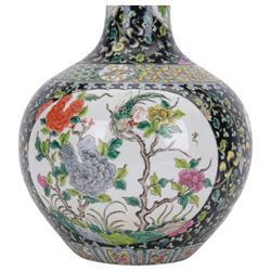 19th century Chinese famille noire bottle vase, decorated with two large reserves painted with ho ho birds amidst blossoming peonies, and six smaller reserves of flowers, against a black ground profusely decorated with leafy tendrils, with character mark beneath, H36cm