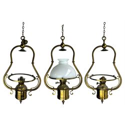 Set three brass framed light fittings, one with white glass shade, converted to electricity, H64cm