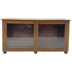 Early 20th century mahogany bookcase, rectangular top over two glazed doors, fitted with four adjustable shelves, on turned bun feet 