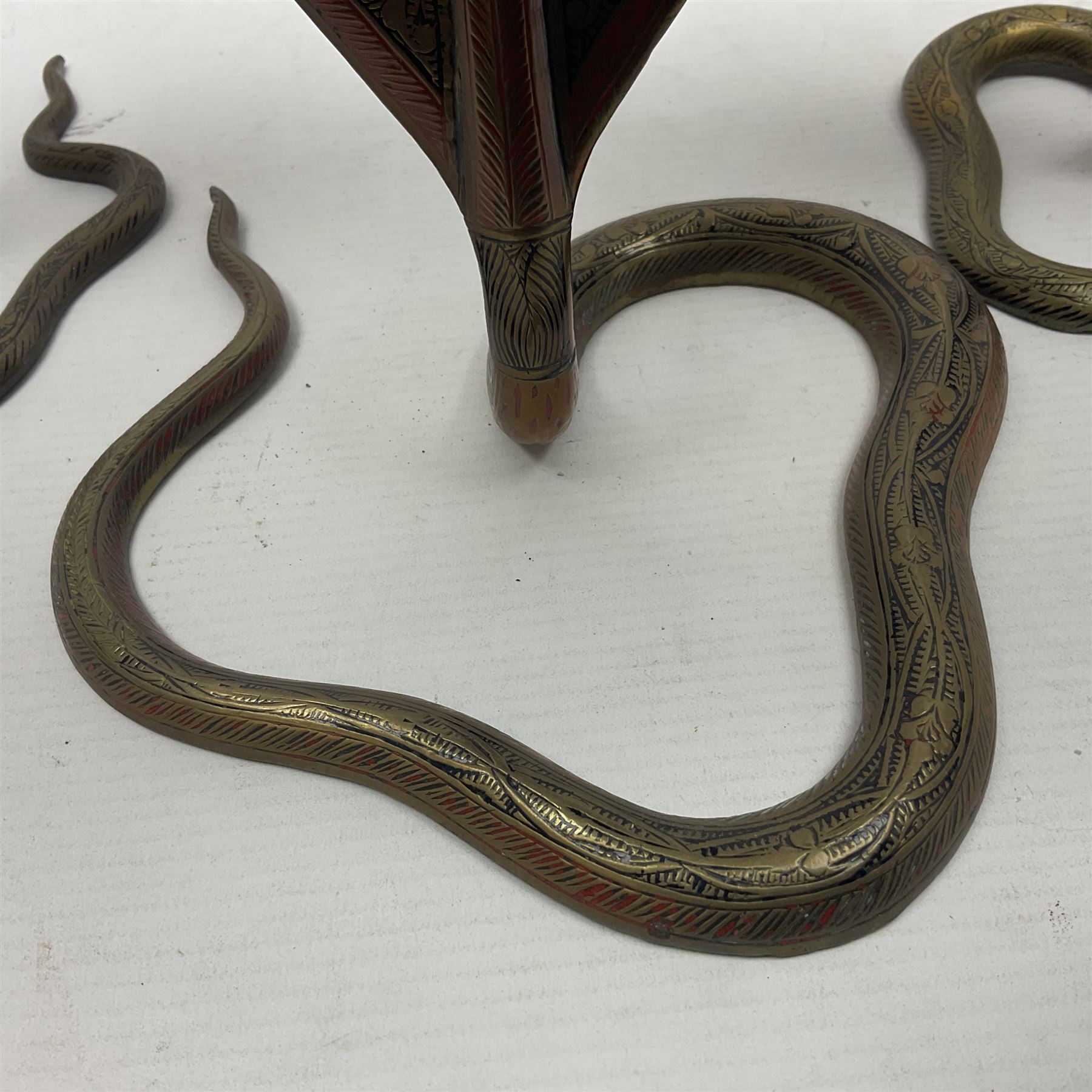 Indian brass pedestal dish, the dish engraved with peacock to centre, the stem modelled as a King Cobra, with engraved and enamelled decoration throughout, together with a similar pair of candlesticks, modelled as King Cobras, dish H23.5cm 