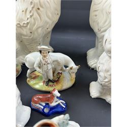 Staffordshire and Staffordshire style figures, to include a chained hound upon a blue oval base in the manner of Samuel Alcock, two pairs of seated Spaniels, a pair modelled as male figure and milk maid with cows, pair of recumbent Greyhounds, etc.