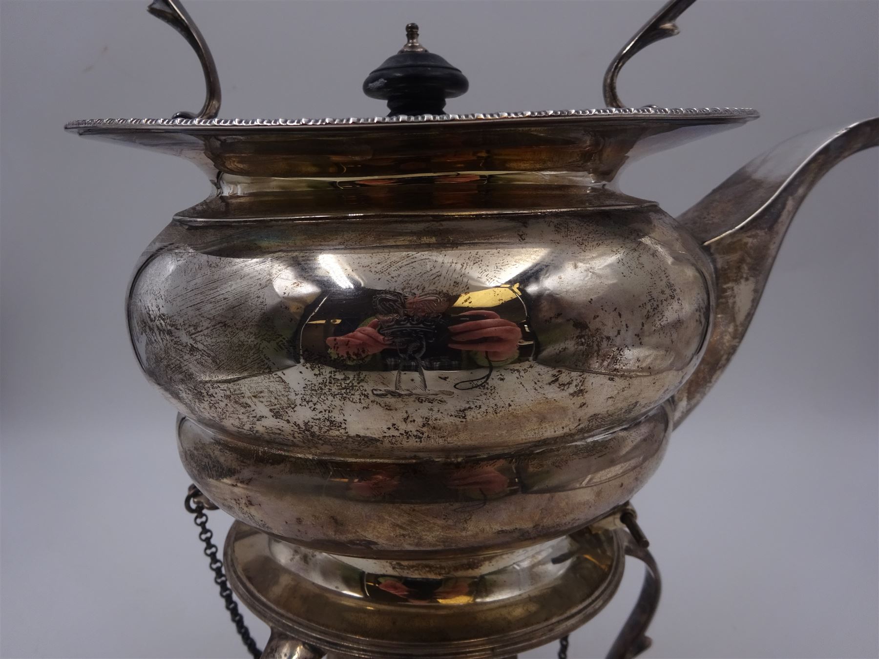 Early 20th century silver spirit kettle and burner, of oval form, with oblique gadrooned rim, engraved crest and ebonised handle and finial, the stand upon three scrolling pad feet, hallmarked Goldsmiths Silversmiths Company, London 1913, total H31cm