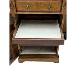 Late Victorian oak twin pedestal desk, chamfered rectangular top over three convex front edge drawers and two panelled cupboards, flanked by carved supports with roundels and diamond motif, on bracketed plinth base