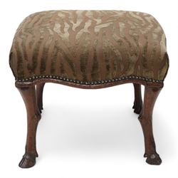 Victorian walnut footstool, the over-stuffed seat upholstered in dark green animal print fabric with stud band, on carved deer leg supports with hoof feet