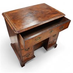 George II figured walnut knee-hole desk, the rectangular quarter-matched veneer top with moulded edge, crossbanding and feathered-banding, fitted with single frieze drawer over three drawers to each side, each with the central recess fitted with a single cupboard enclosing shelf, lower moulded edge on bracket feet