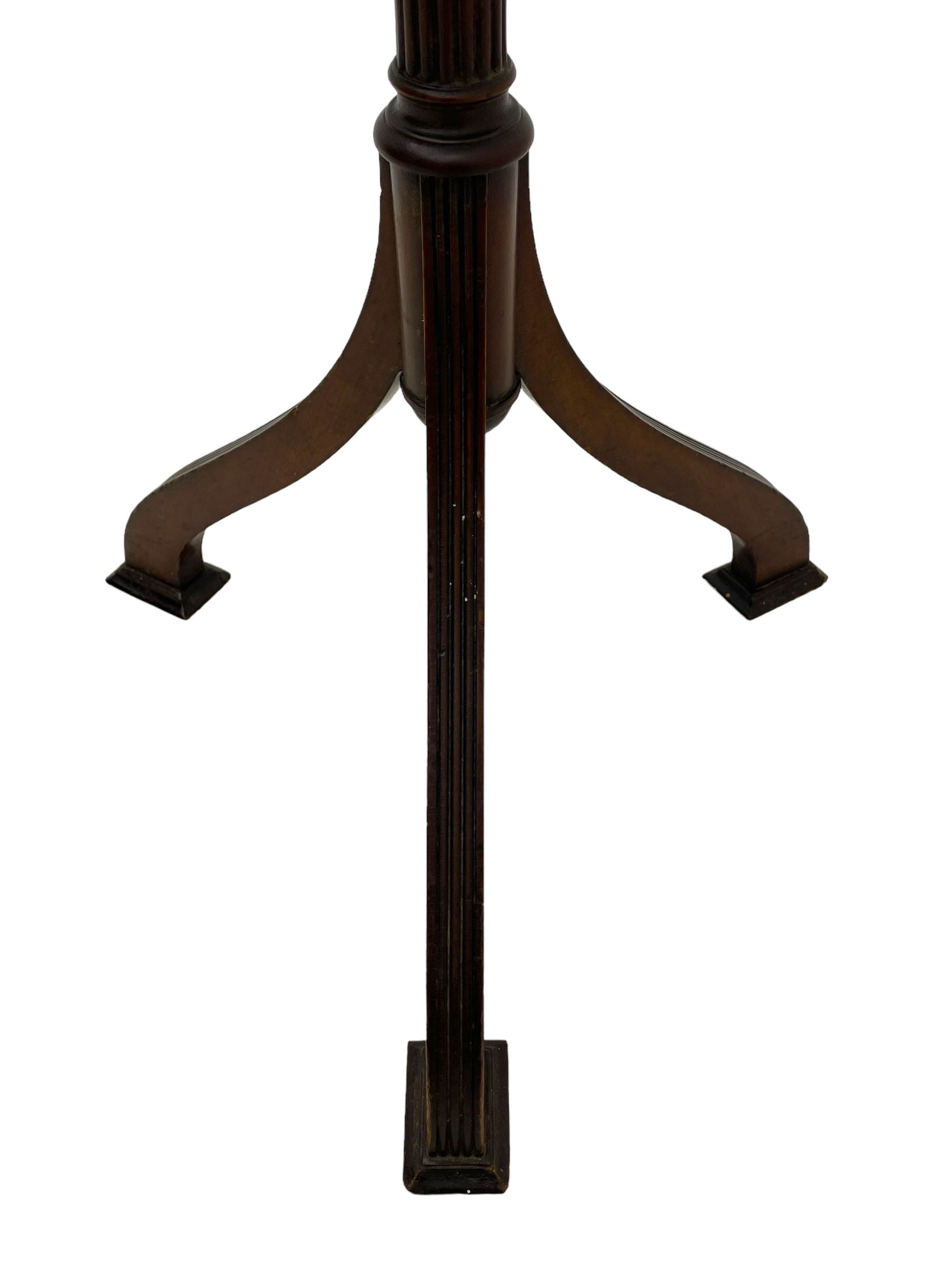 Early 20th century mahogany wine table, figured circular top with reeded edge, on turned and reed moulded stem, three reeded tapered supports on rectangular moulded pad feet 