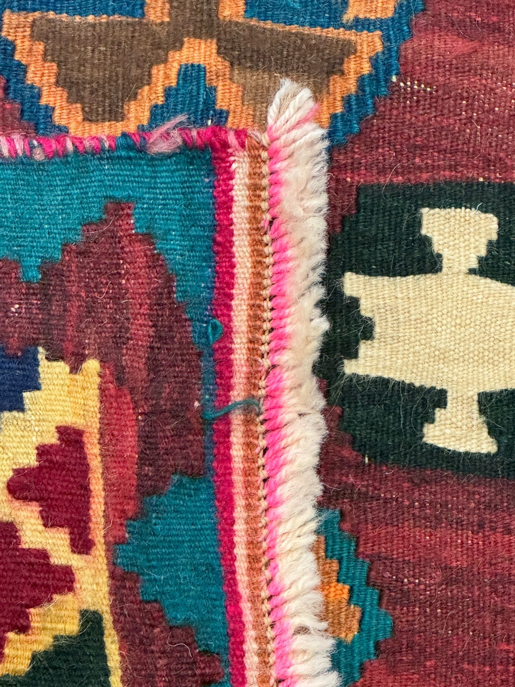 South West Persian Qashqai Kilim, crimson ground and decorated with three rows of geometric motifs, within zig-zag borders 