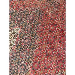 Perisian Bidjar crimson ground rug, within scalloped borders, central pole medallion, the field decorated all over with floral Herati motifs, guarded border decorated with repeating stylised plant motifs and trailing branch 