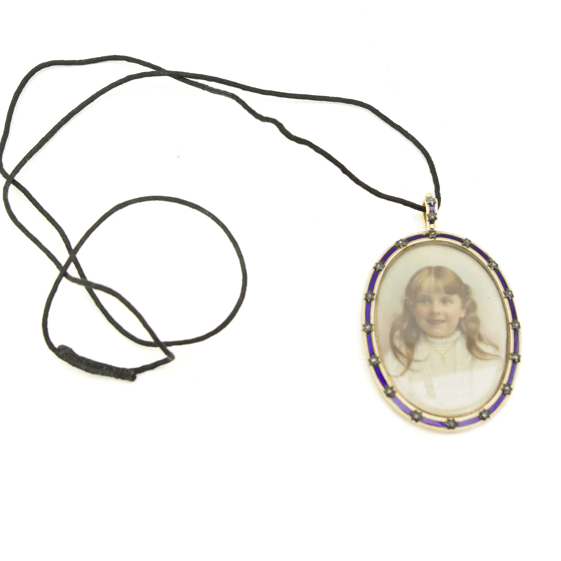 Early 20th century portrait miniature of a head and shoulder of a girl on ivory, mounted in 9ct gold locket pendant, with white and blue enamel border, with applied diamond chip star decoration. This item has been registered for sale under Section 10 of the APHA Ivory Act