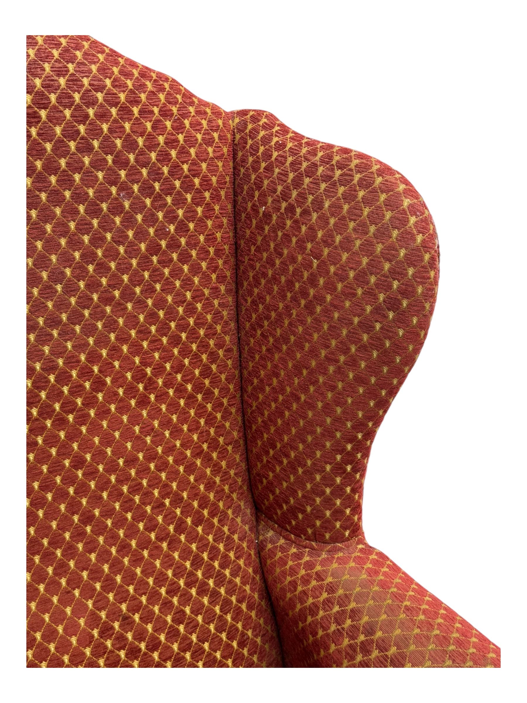 Early 20th century hardwood-framed wingback armchair, upholstered in red dotted fabric, on cabriole feet