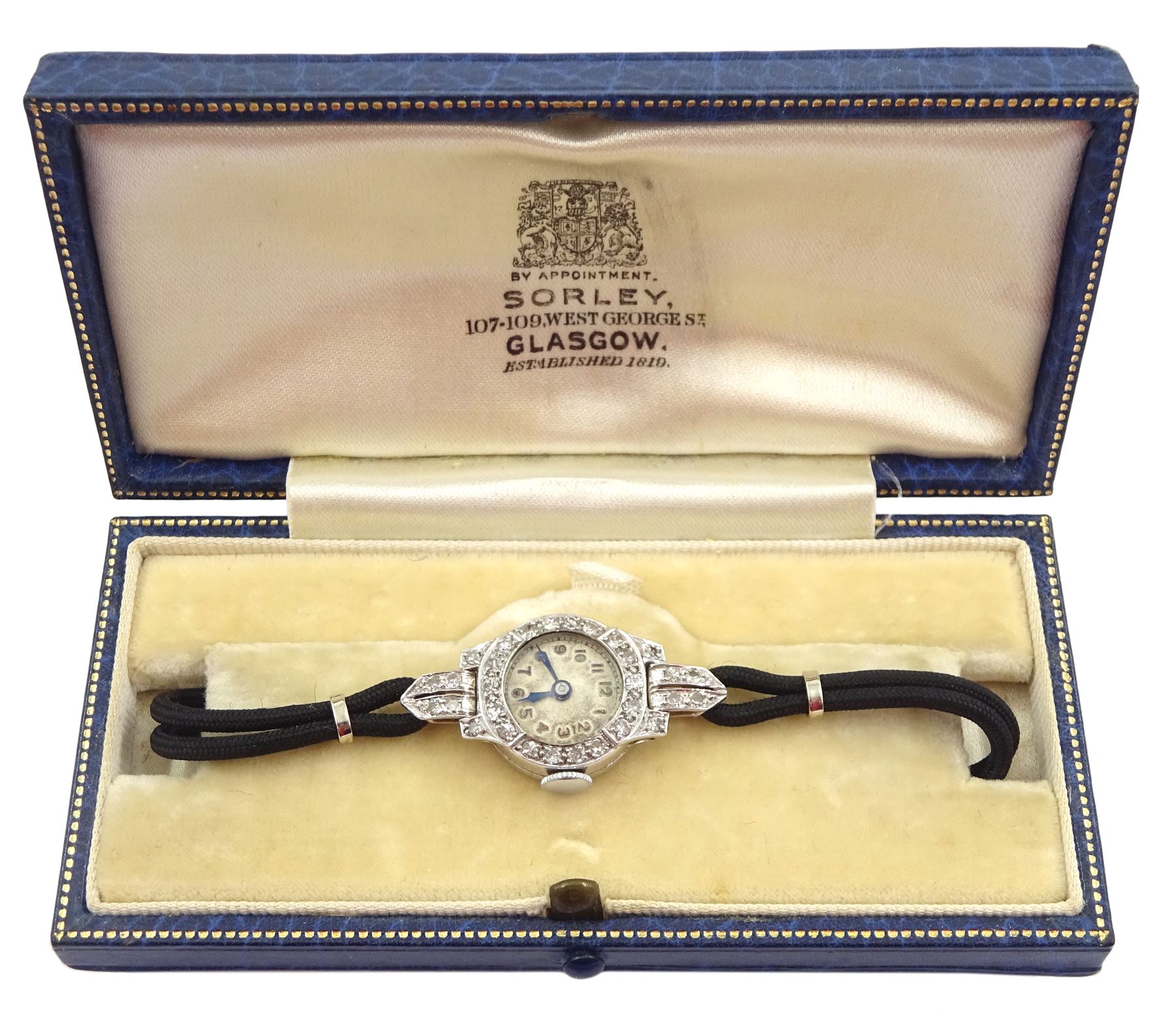 Art Deco platinum diamond set manual wind wristwatch, on black cord bracelet, with 9ct white gold clasp, cased