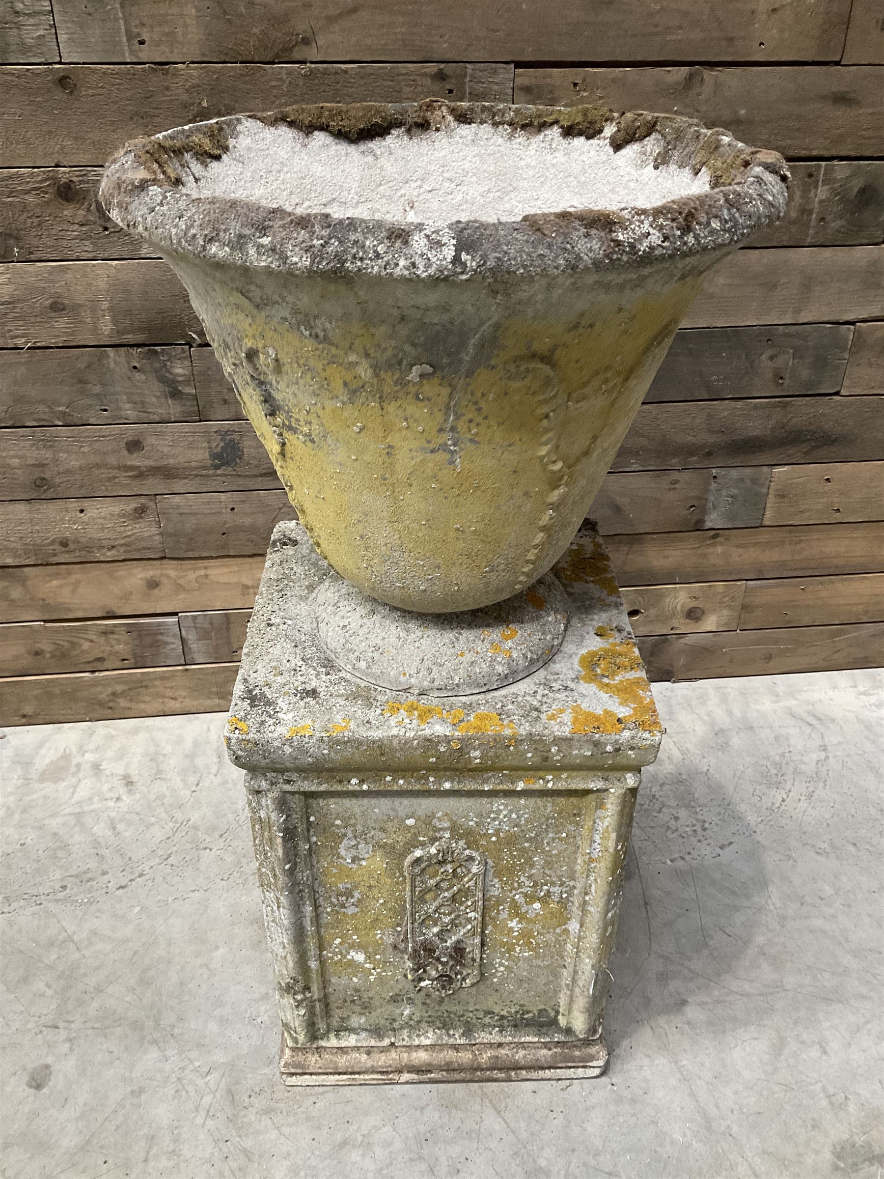 Cast stone vase shaped urn, mounted on square plinth