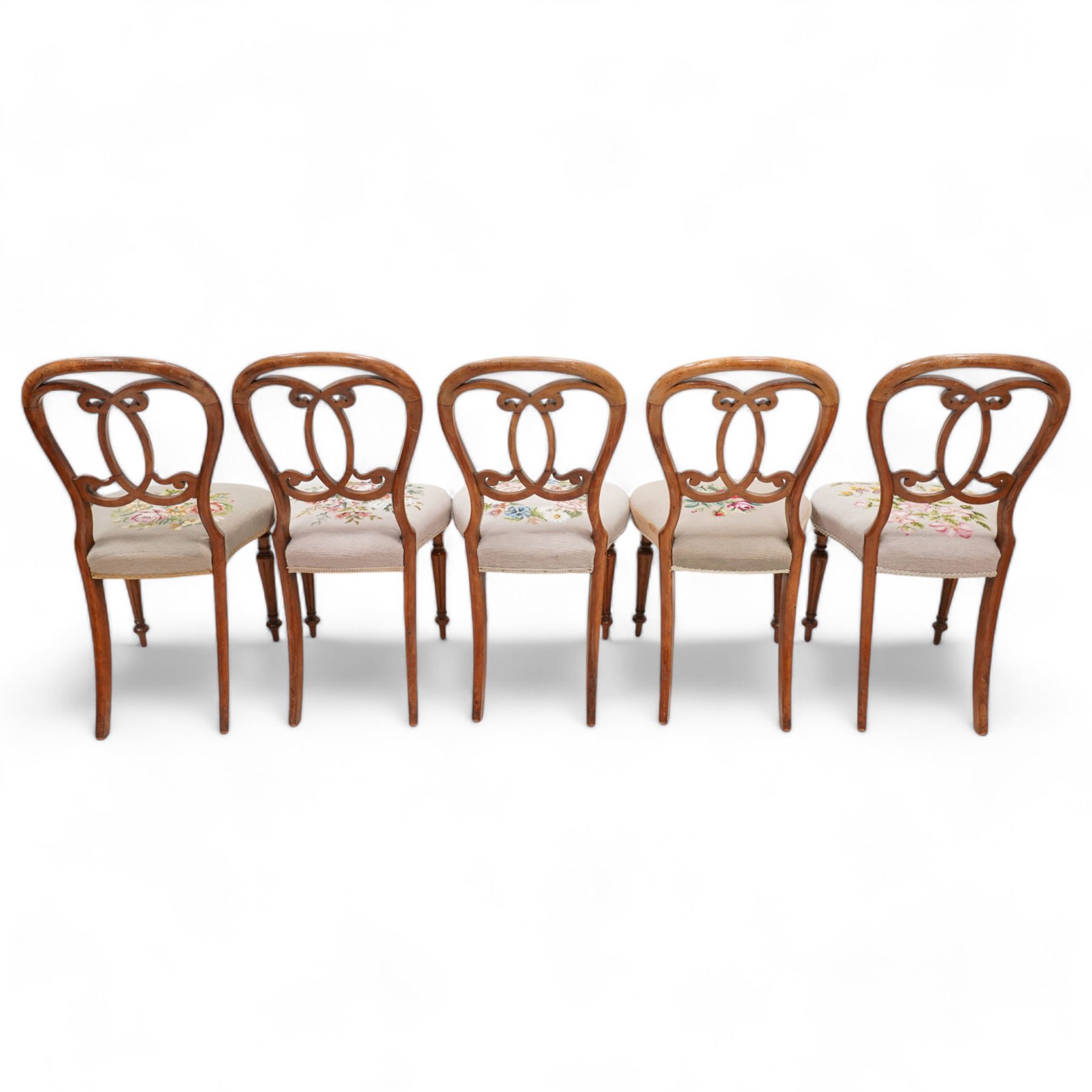 Set of five Victorian walnut balloon back dining chairs, interlaced C-scroll back over floral tapestry seat, on turned and fluted supports 