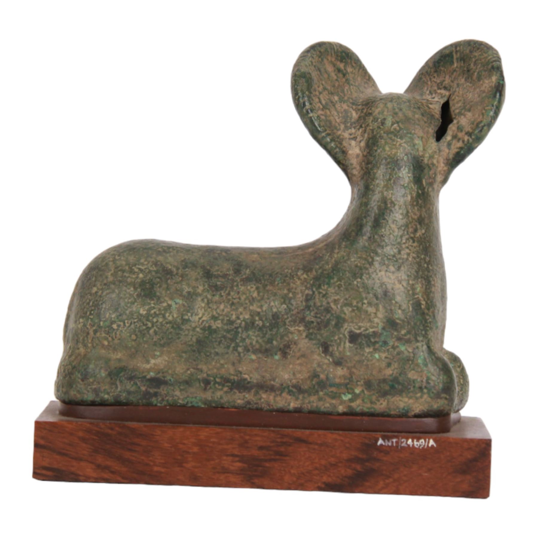 Bronze figure of a goat, probably Roman, modelled in recumbent position with legs tucked beneath body, upon later wooden plinth, overall H14.5cm W15cm