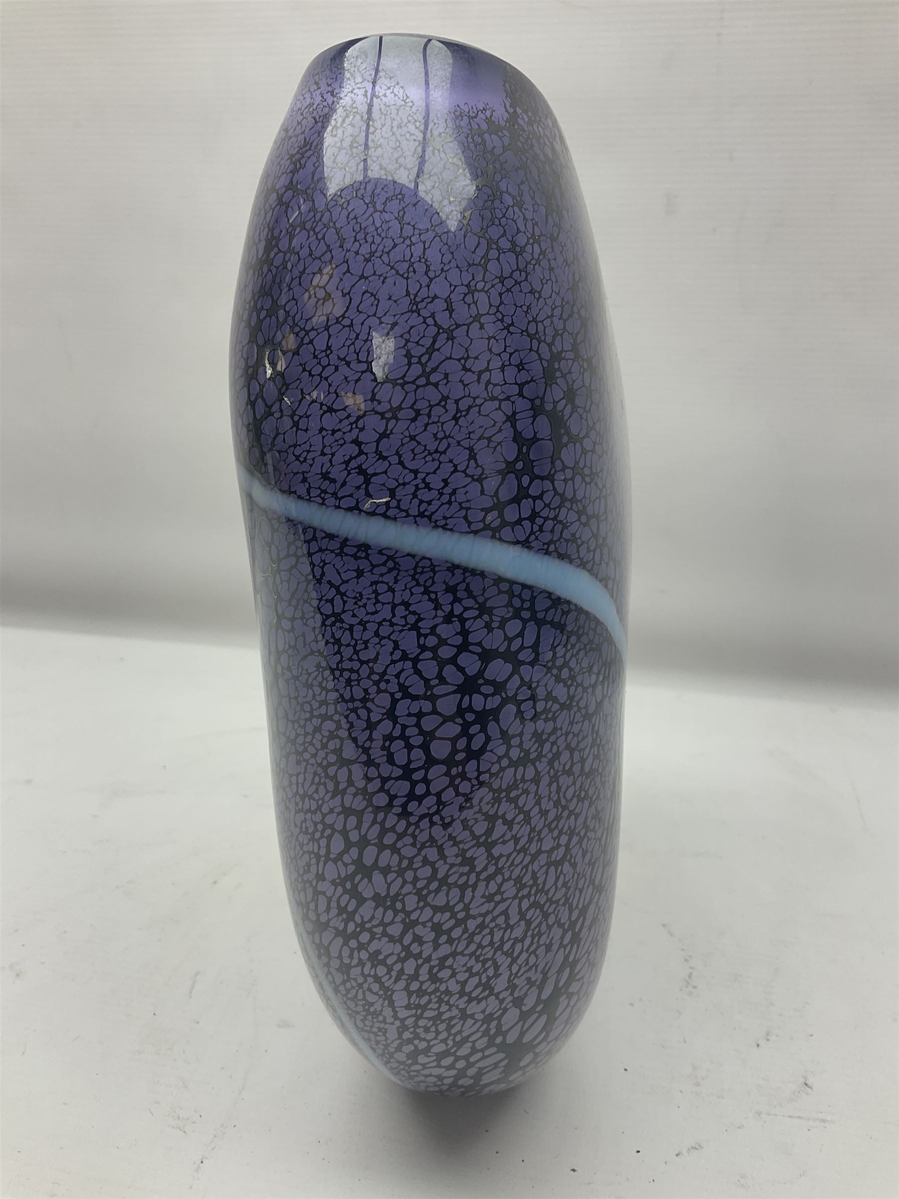 Stuart Akroyd glass vase, with blue ribbon decoration upon a mottled purple ground, engraved signature and sticker beneath, H25.5cm