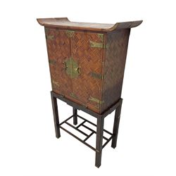 Chinese design bamboo and wood altar cabinet on stand, parquetry lattice-work bamboo, two doors with engraved metal fixtures enclosing drawers and shelf, fitted with slide, the stand pm square supports joined by a series of geometric stretchers