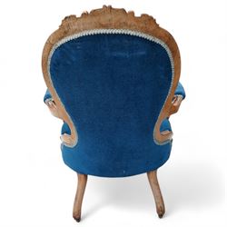 Victorian walnut framed open armchair, curled leaf carved cresting rail over scrolled and shaped arms, upholstered in buttoned blue velvet fabric, on cabriole feet