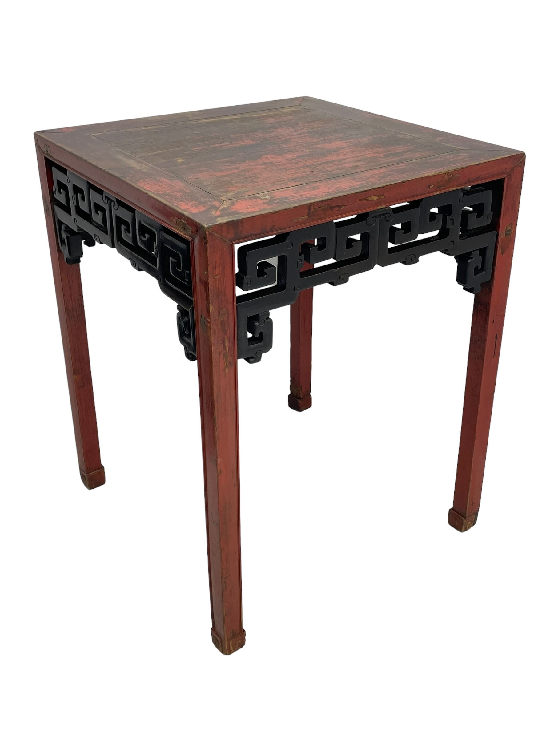 Late 19th century Chinese Qing dynasty red and black lacquered wood tall tea table, Shanxi region, square top over geometric scroll fretwork panels, on square supports with hoof feet 