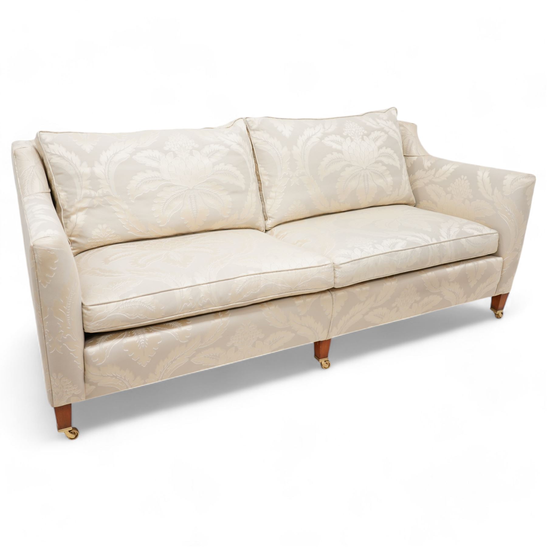 Duresta - Grande hardwood-framed three-seat sofa, upholstered in pale fabric decorated with repeating foliate pattern, on square tapering supports with brass castors 