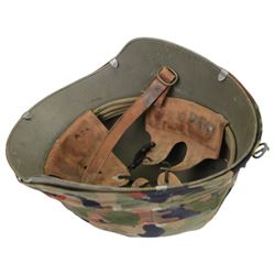 Collection of nine military helmets, including several with camouflage covering 