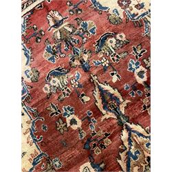 Persian Mahal red ground rug, central floral design pole medallion on a field decorated with flowerheads and foliage, the border decorated with trailing leafy branch and flowerheads 