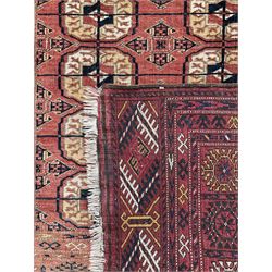 Bokhara rust ground rug, decorated with two rows of Gul motifs (175cm x 113cm); Persian design rug, the busy field decorated with geometric patterned stripes (144cm x 94cm)