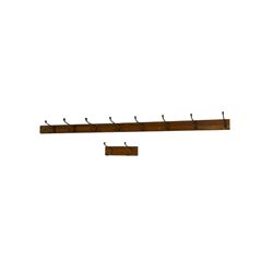 Late 19th century pitch pine wall hanging coat rail, fitted with metal hooks, two sections (longer section - L240cm; smaller section - 40cm)