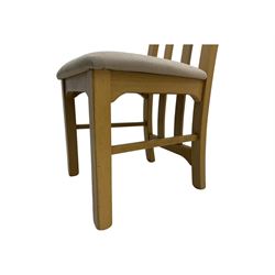 Contemporary set of four oak dining chairs, tall slatted curved backs with square cutouts to the top, upholstered seats in light fabric, on square front supports