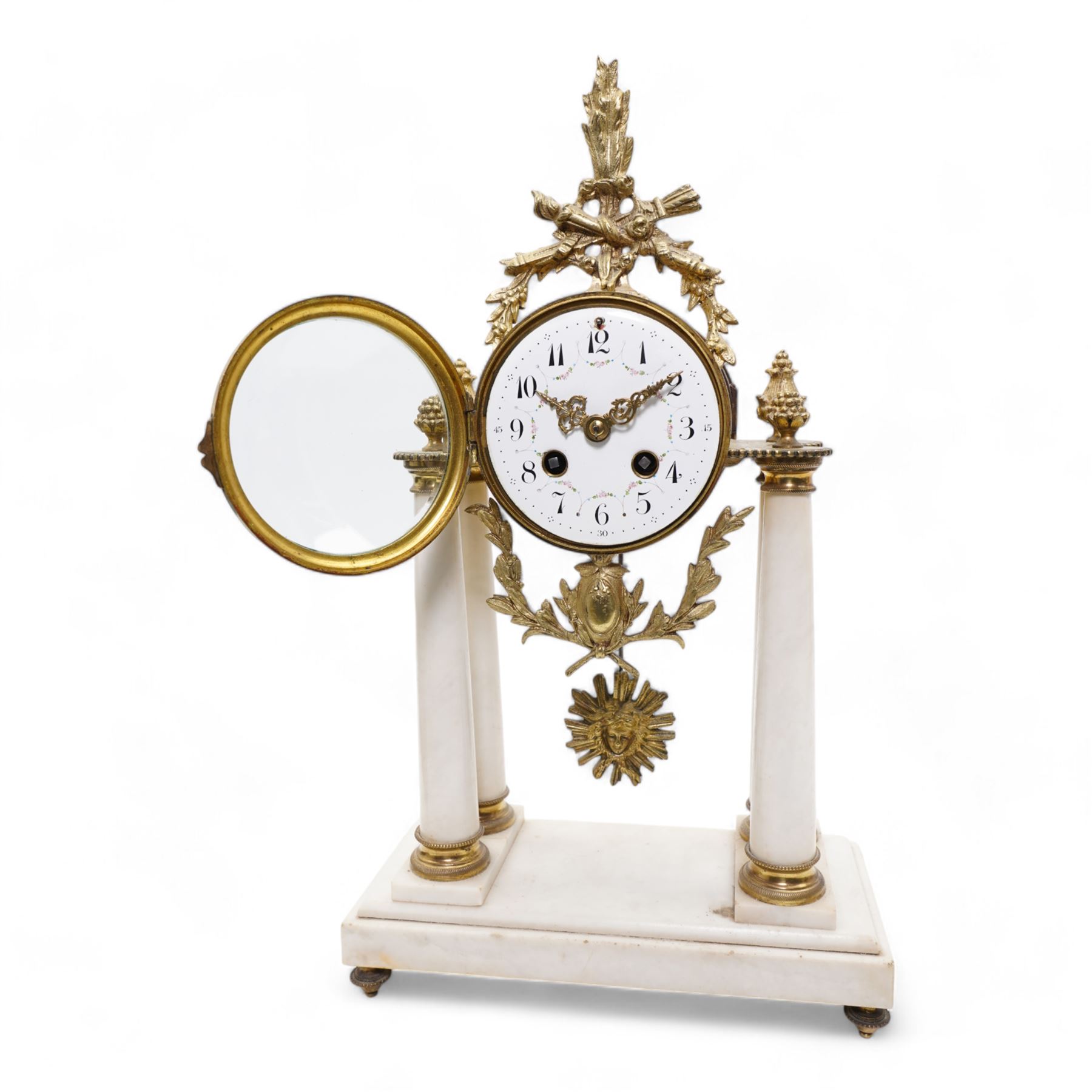 French - White marble and gilt 8-day mantel clock c1900,  with a rectangular plinth raised on four feet, gilt drum movement supported on four tapered pillars with gilt torus base and pineapple finials, convex enamel dial with floral swags and Arabic numerals, minute markers and gilt Louis XV hands, twin train Parisian countwheel striking movement, striking the hours and half-hours on a bell. With a sunburst pendulum.