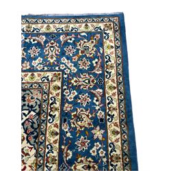 Persian Nain blue ground carpet, overall arabesque design, centre rosette medallion with eight projecting palmettes, the surrounding field decorated with interlacing branches and stylised plant motifs, within floral pale ground spandrels, the guarded border decorated with repeating stylised floral pattern 