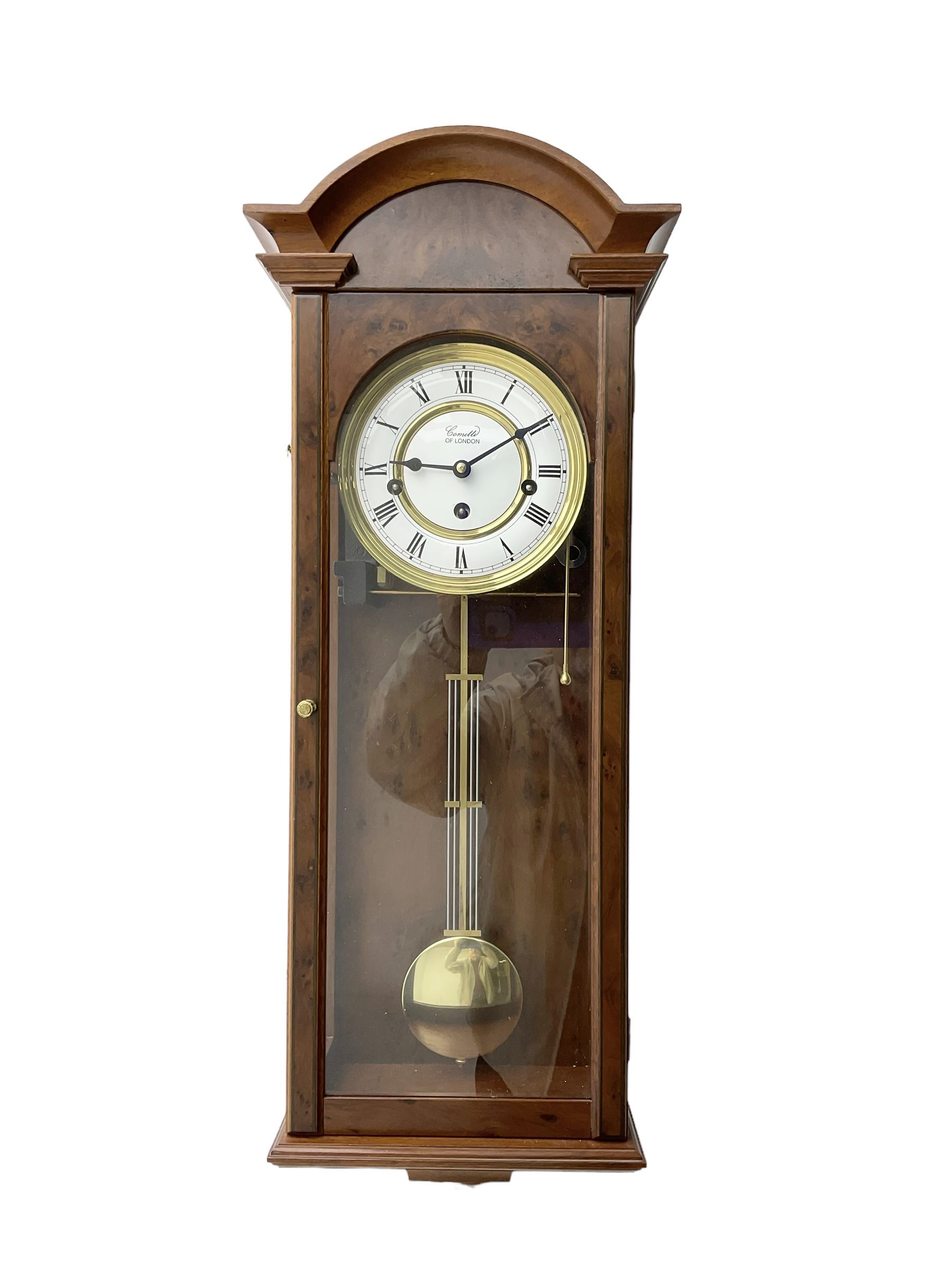 Comitti,  London - 20th century 8-day chiming wall clock in a walnut case, with a moulded break-arch top and full length glazed door and side panels, two part enamel dial with spade hands and visible gridiron pendulum, three train spring driven movement chiming the quarters on 5 gong rods.