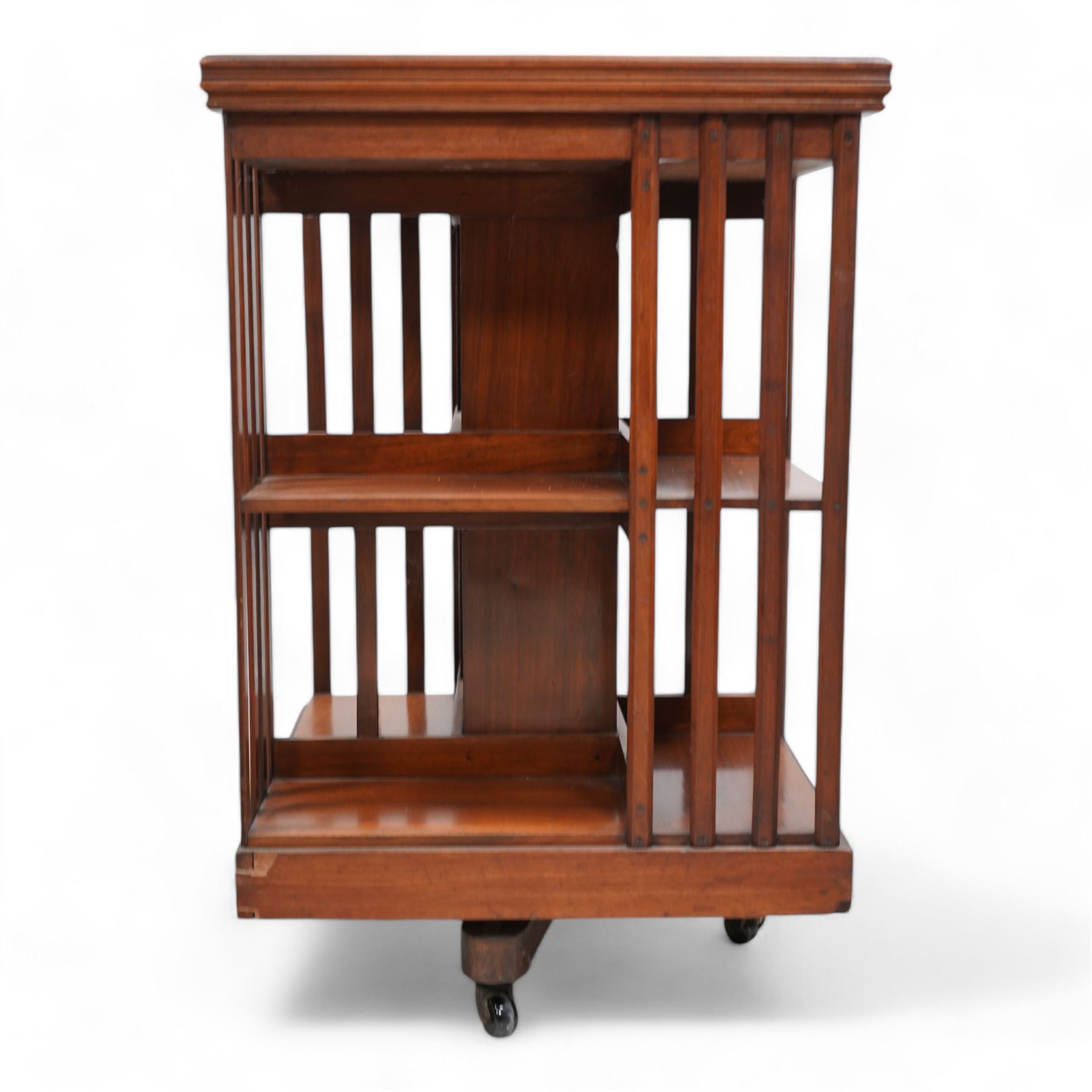 Edwardian mahogany revolving bookcase, square form with moulded top, two tiers with vertical moulded slats, on brass and ceramic castors 