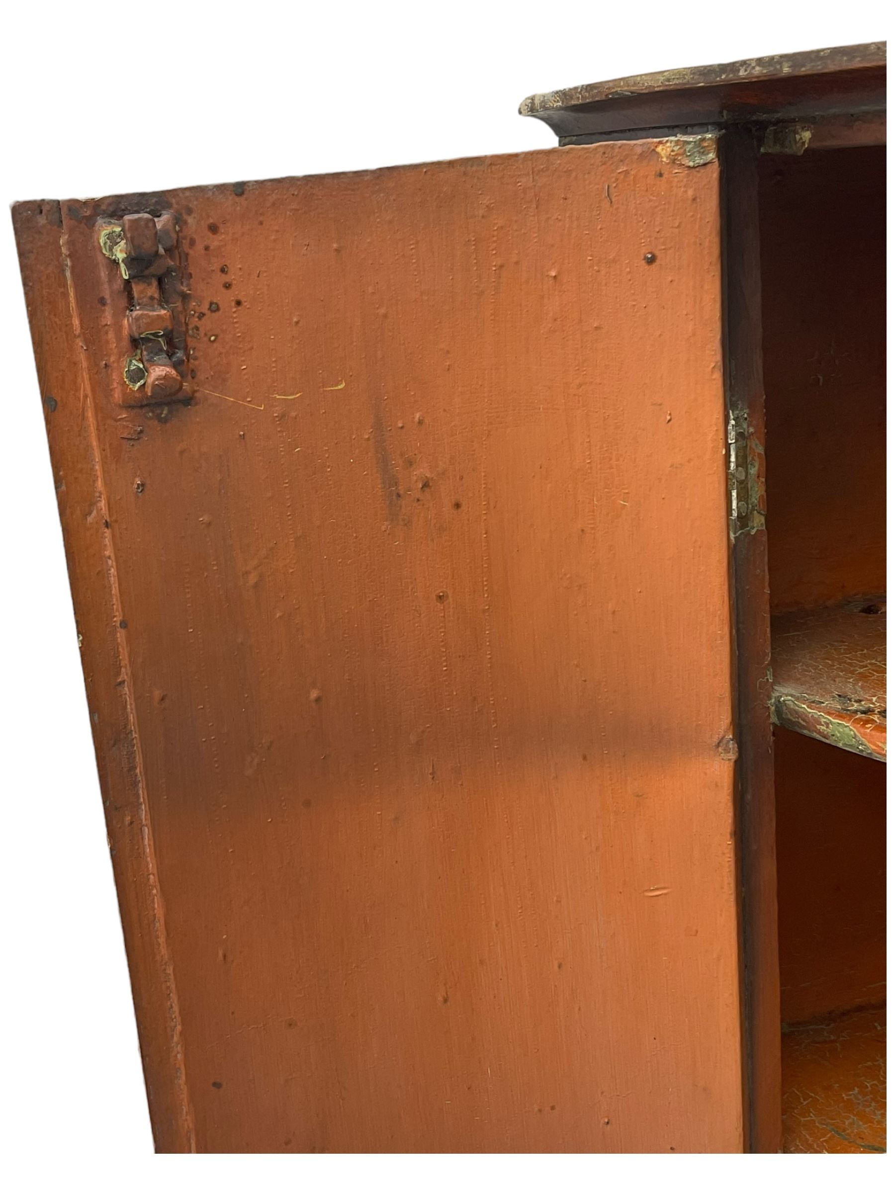 George III mahogany bow-front corner cupboard, enclosed by two figured doors with brass hinges and escutcheon, the painted interior fitted with three shelves 