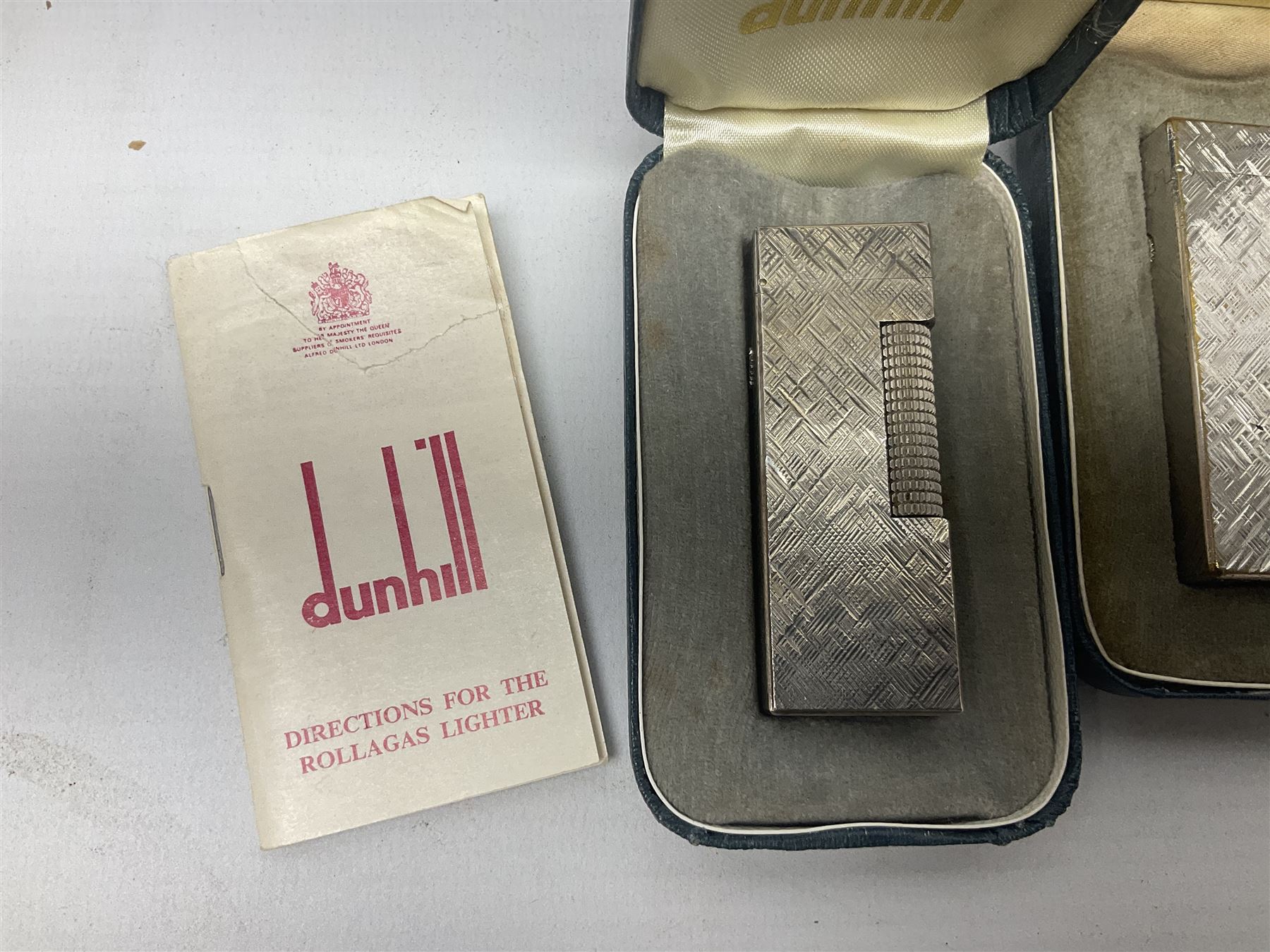 Three Dunhill silver plated lift-arm lighters, of rectangular form with engine turned decoration, marked Dunhill, two with original cases 