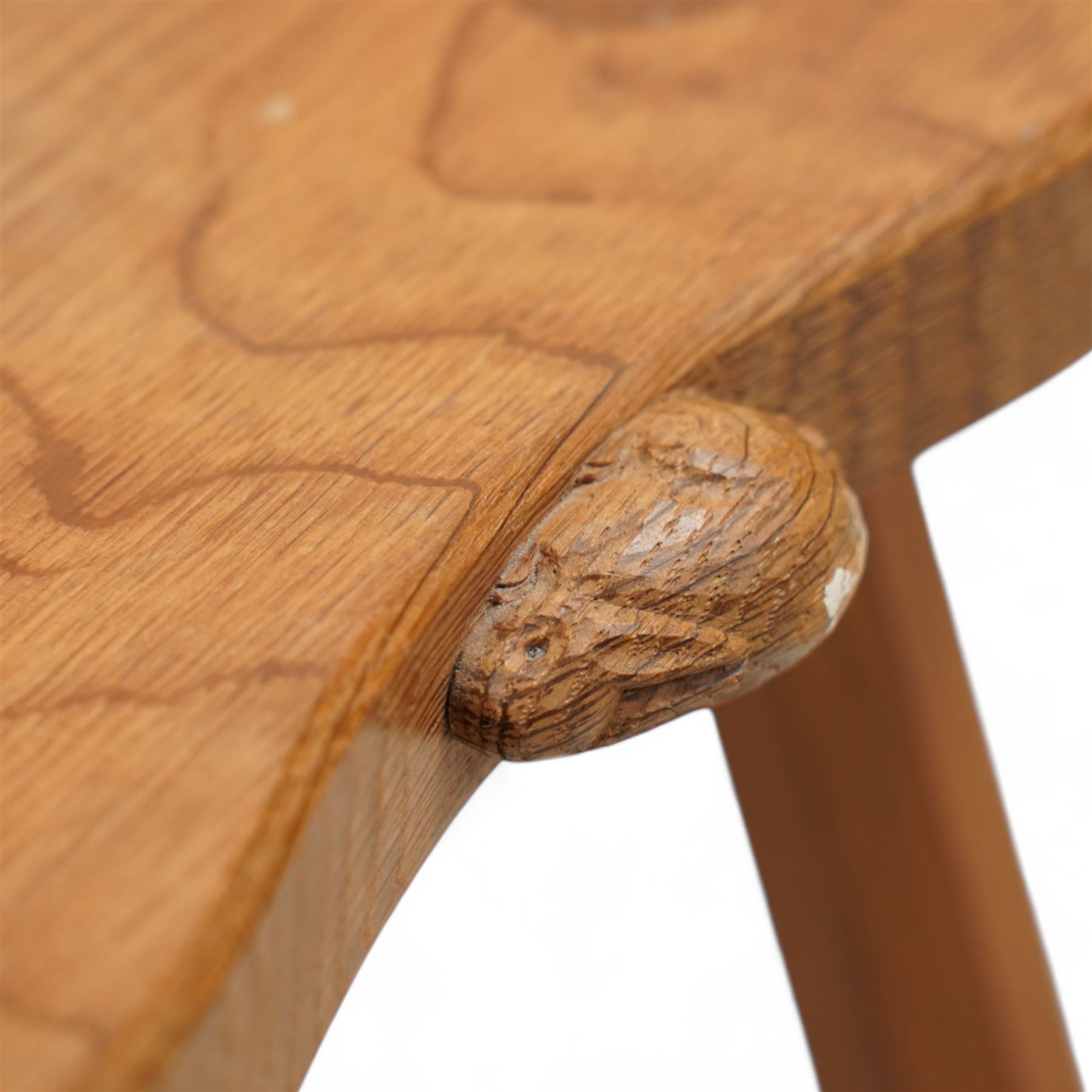 Rabbitman -  oak milking stool, dished kidney shaped top, on three tapered octagonal supports, carved with rabbit signature, by Peter Heap, Wetwang