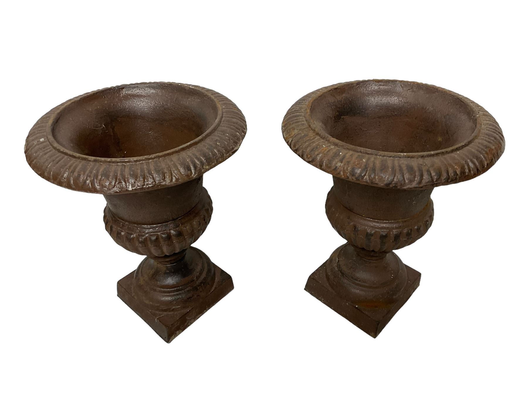 Two pairs of cast iron Campana-shaped garden urns, egg and dart moulded rim over gadrooned underbelly, on circular foot and square base 