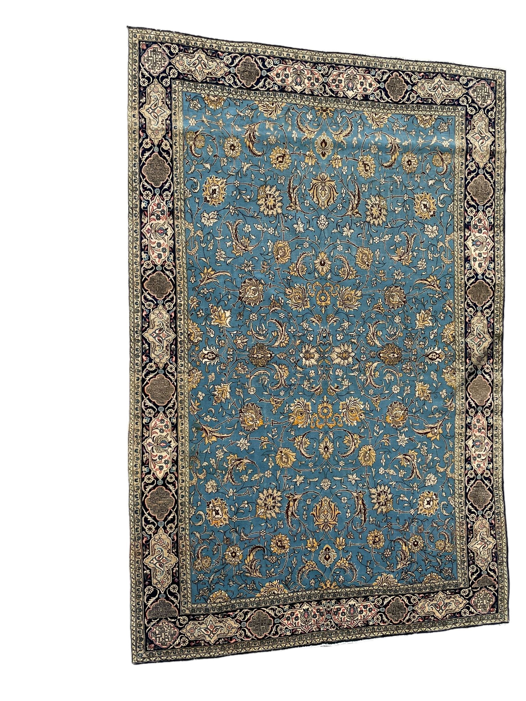 Persian Nain blue ground rug, overall arabesque design, the busy field decorated with interlacing branches and palmettes, indigo ground border with panels decorated with knots and lotus flower motifs, surrounded by trailing branches and flower heads, within guard stripes