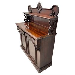 Victorian mahogany chiffonier, raised shaped back with foliage scroll carved mounts, on fretwork and carved bracket supports, moulded rectangular top over two frieze drawers and double panelled cupboard, on moulded plinth base