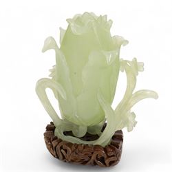 Chinese green jade magnolia form vase, supported on a leafy stem, with flowers and butterflies, on a pierced and carved hardwood stand, H15cm x W14cm